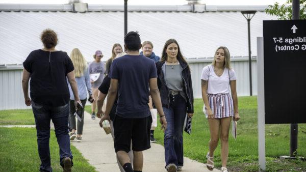 A group of people walking on a sidewalk